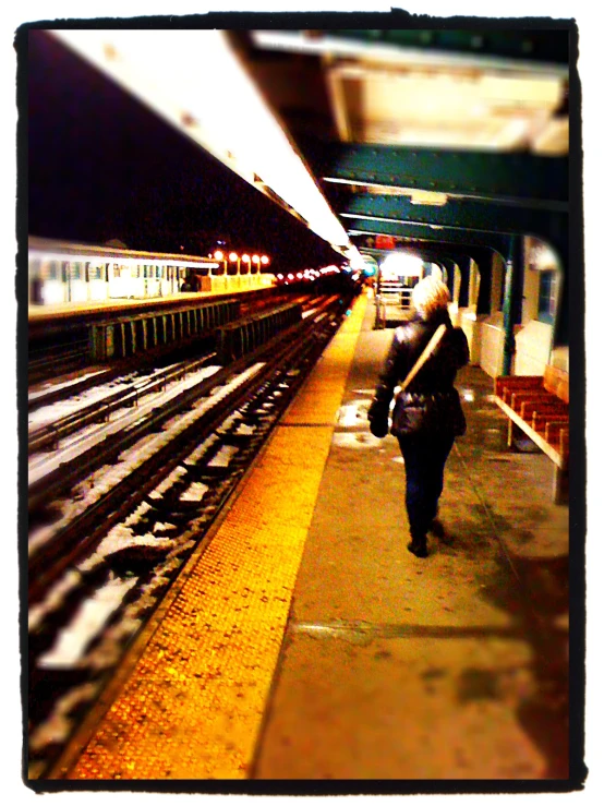 someone walking through a subway station near train tracks