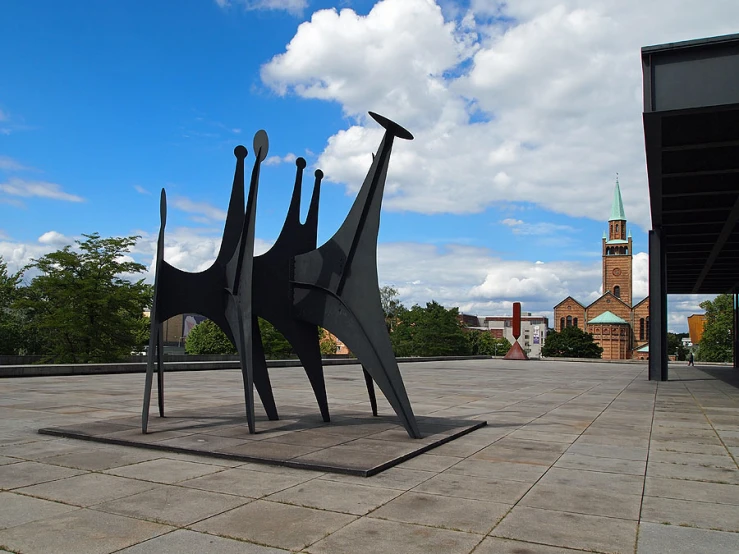 a large metal sculpture of people on a tiled floor