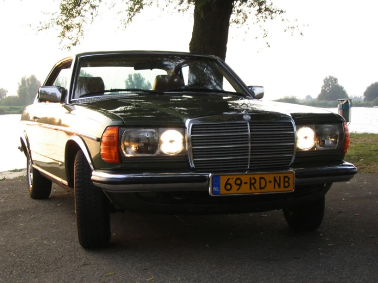 an image of an older mercedes parked in the street