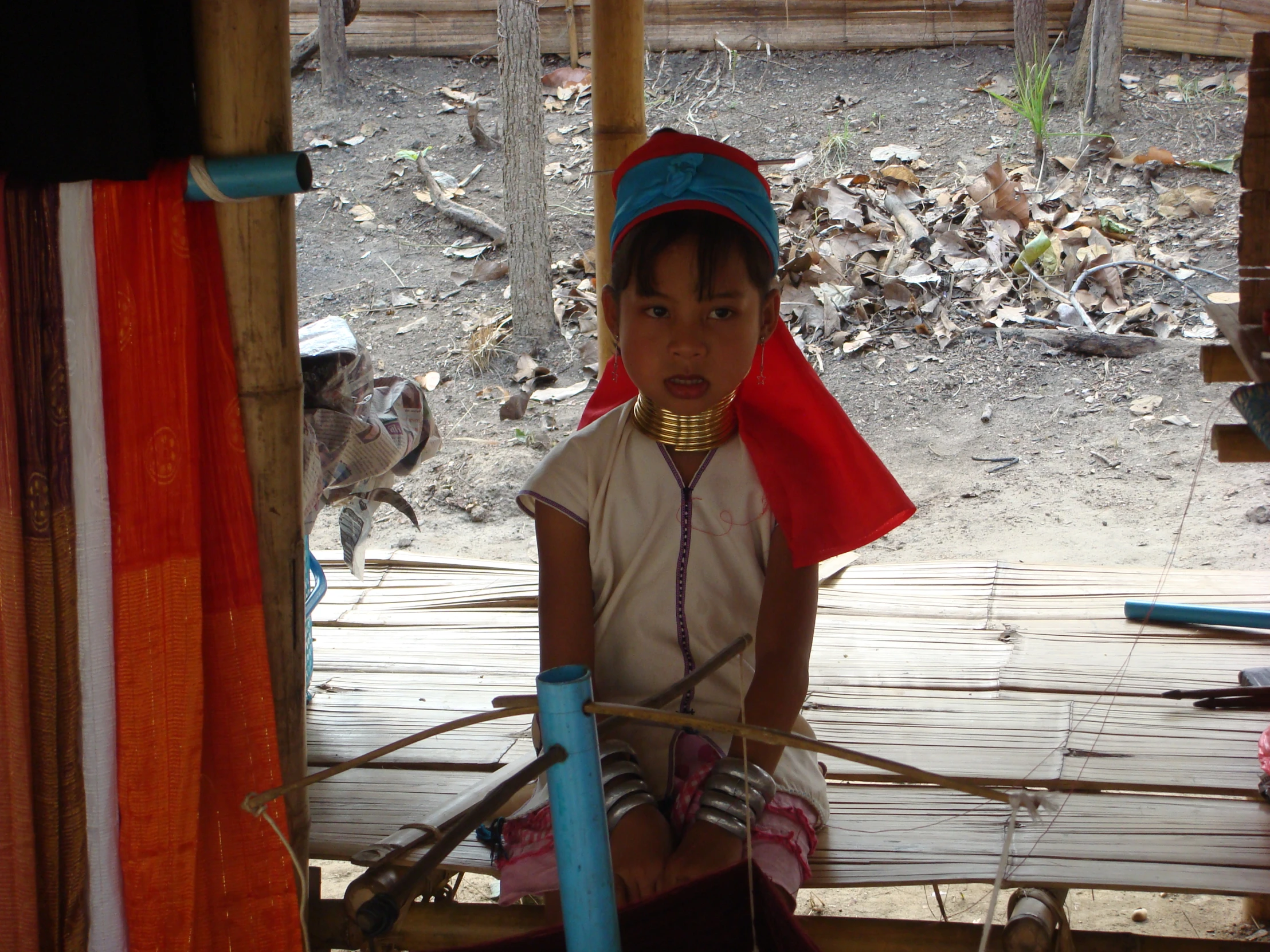 an asian girl looking at camera as she works on the wooden pole