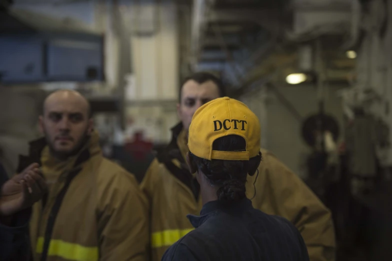 a group of men standing next to each other wearing caps