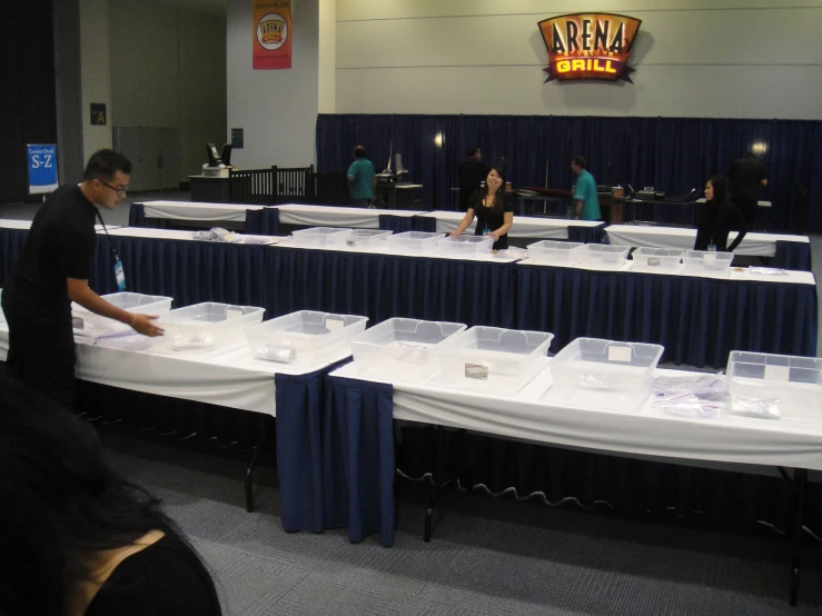 many tables are lined up in an indoor conference hall