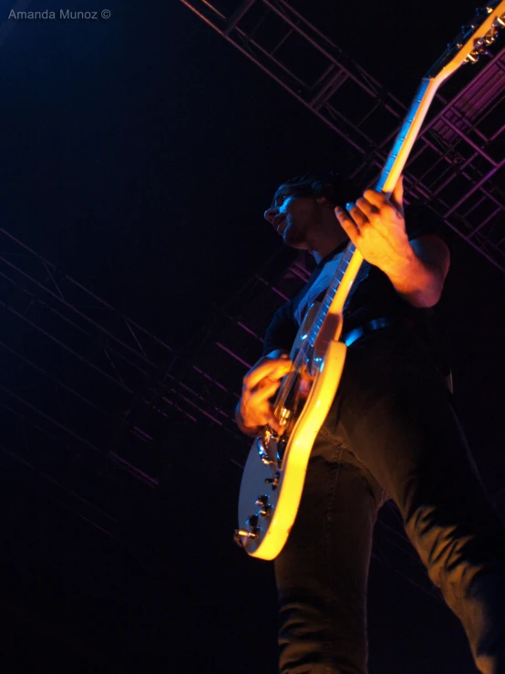 a man holding his guitar while performing