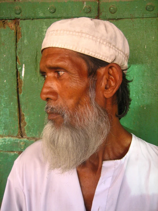 a man with a long beard wearing a white hat