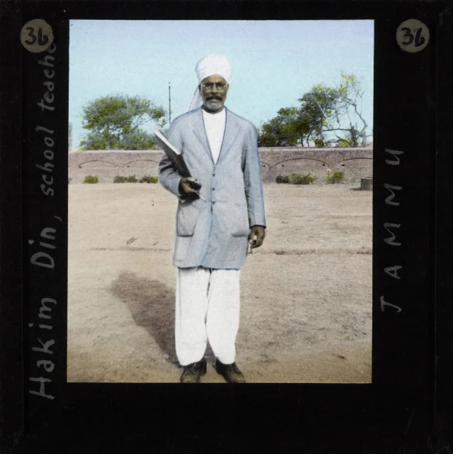 a man with white turban, standing with a gun in his hands