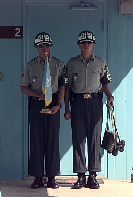 two policemen stand outside of a building next to each other