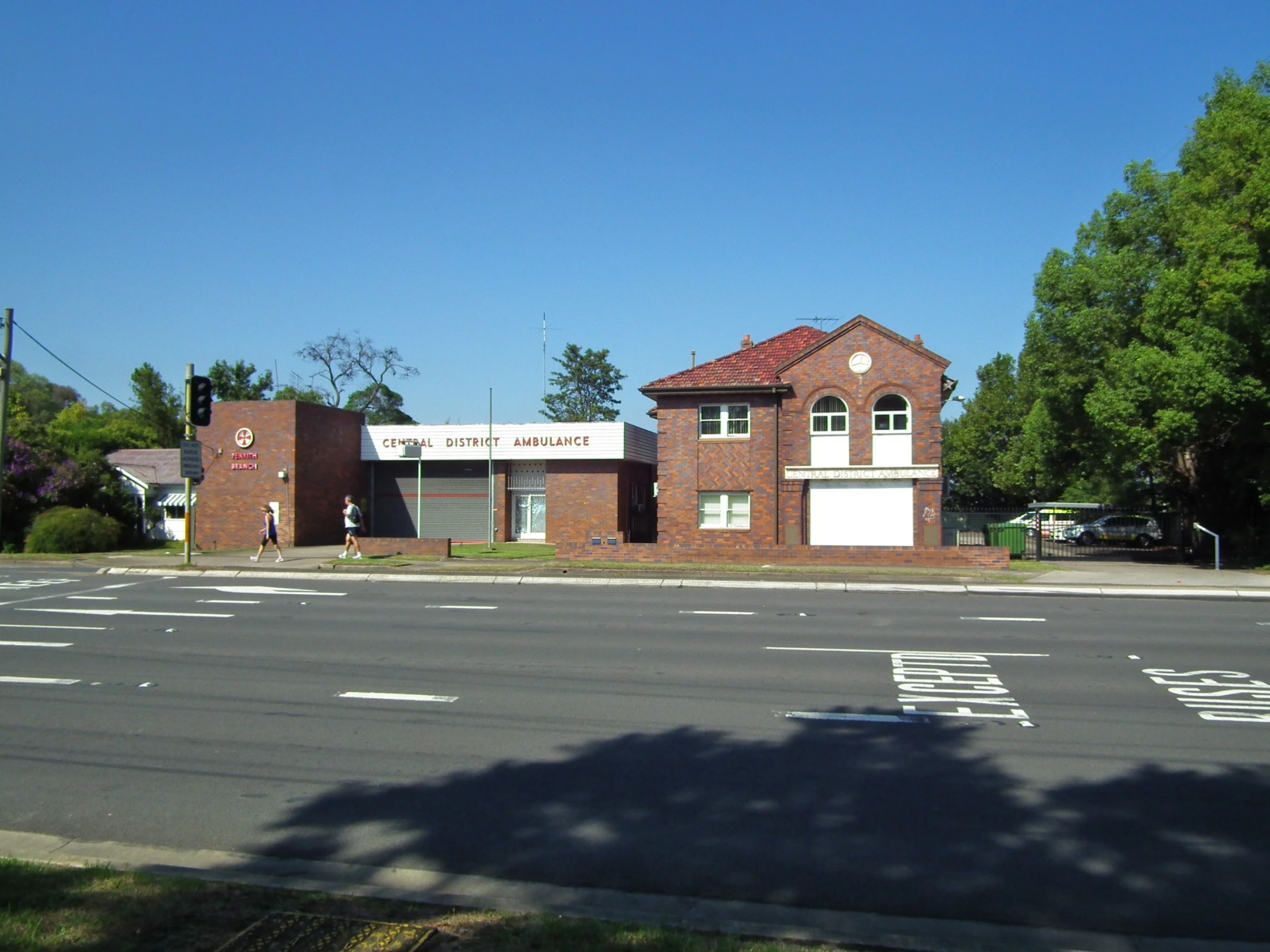 a fire house next to a street with a cross walk on the side of it