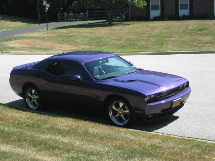 purple sports car parked in the driveway of a house