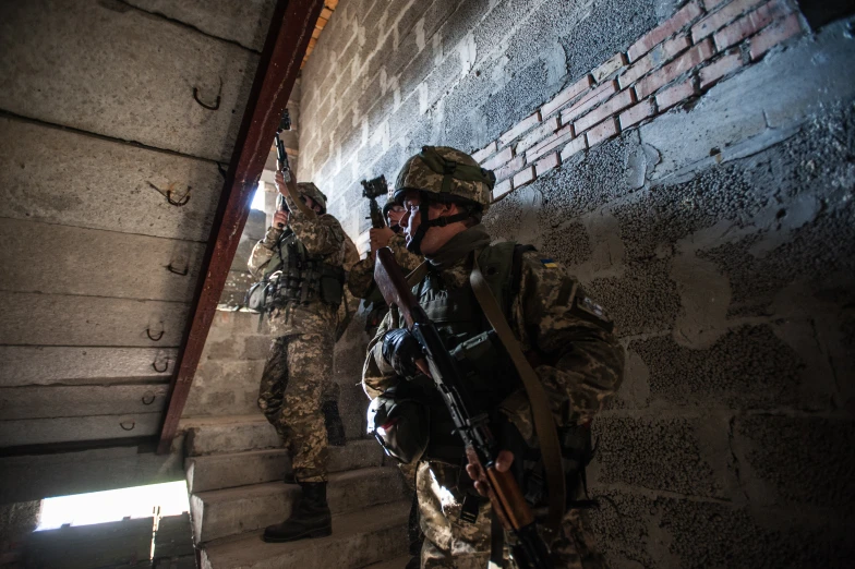 two men with guns in their hands on stairs