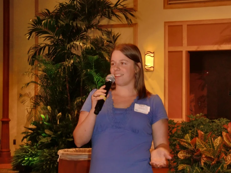 a woman stands with her arm in the air while holding a microphone