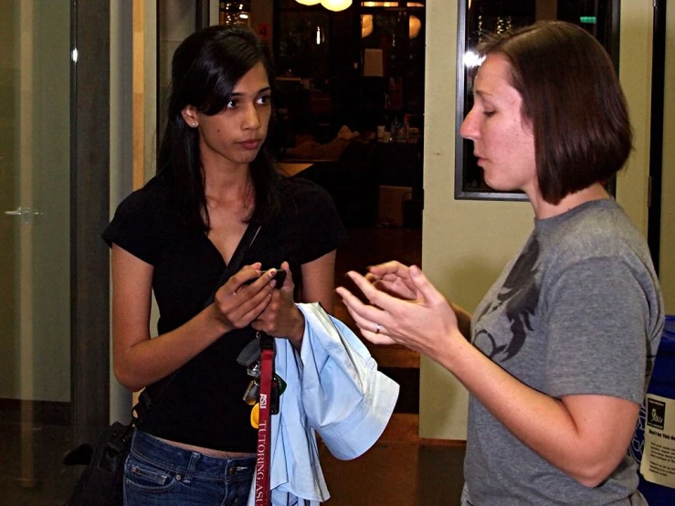 two young ladies talking and hanging out in the hallway