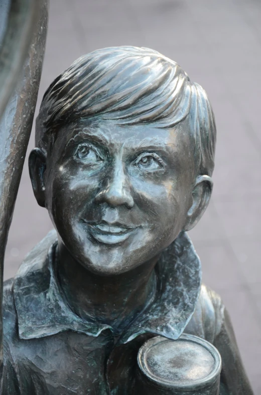 the sculpture of a man with a cane stands on a sidewalk