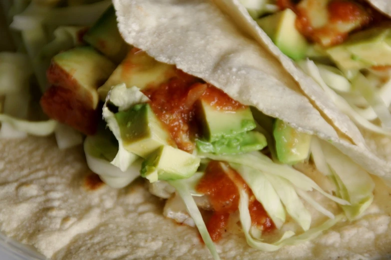 two tacos with cheese and avocado on top