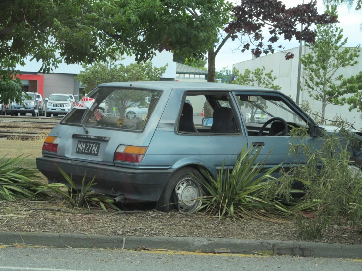 a car parked by the side of the road in the grass