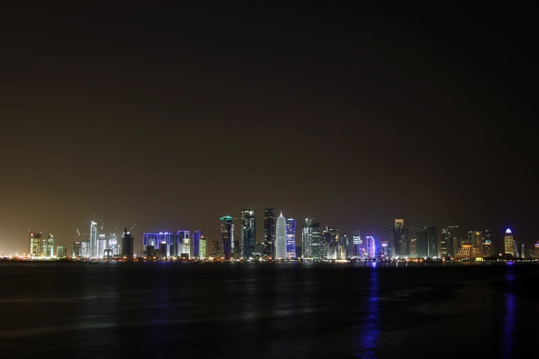 a view of the city lights from the water at night