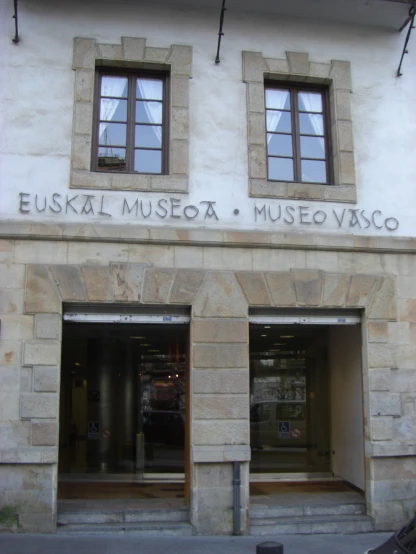 an entrance to a museum with three windows