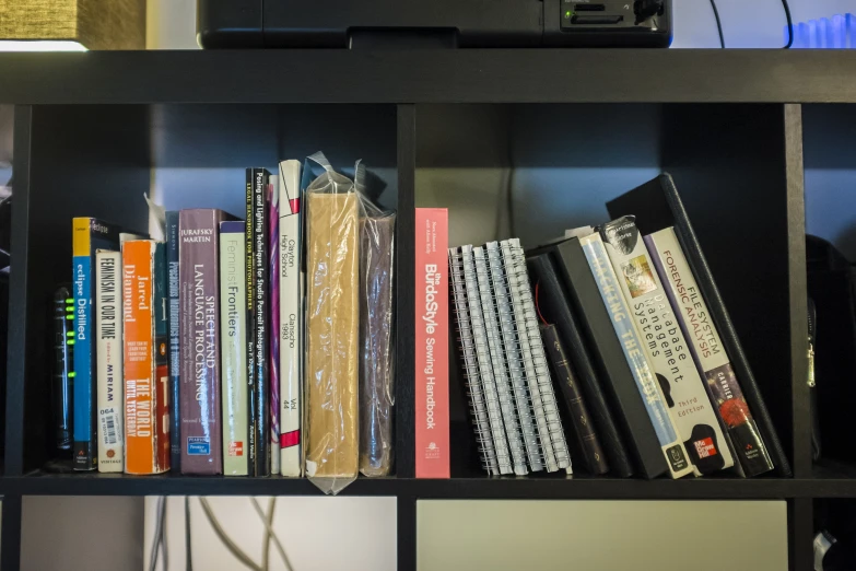 there is a shelf with many books and a computer