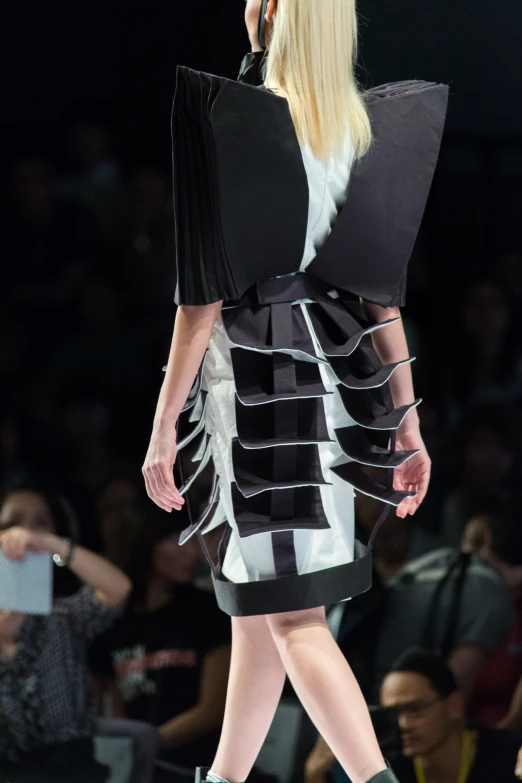 a model walks down the runway in black and white outfits