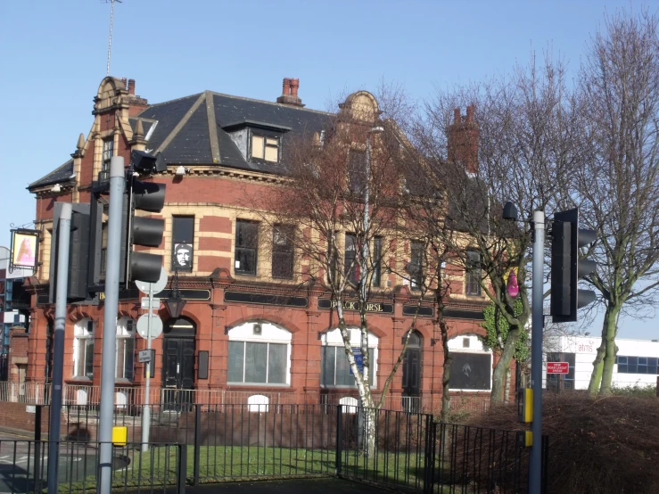 an old red brick building sits on the corner of an intersection