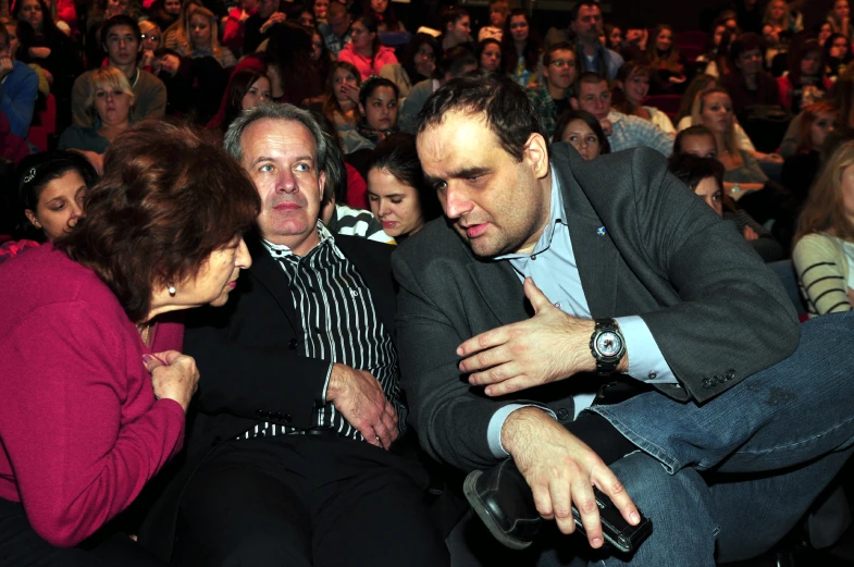 a man in suit is holding a women's watch