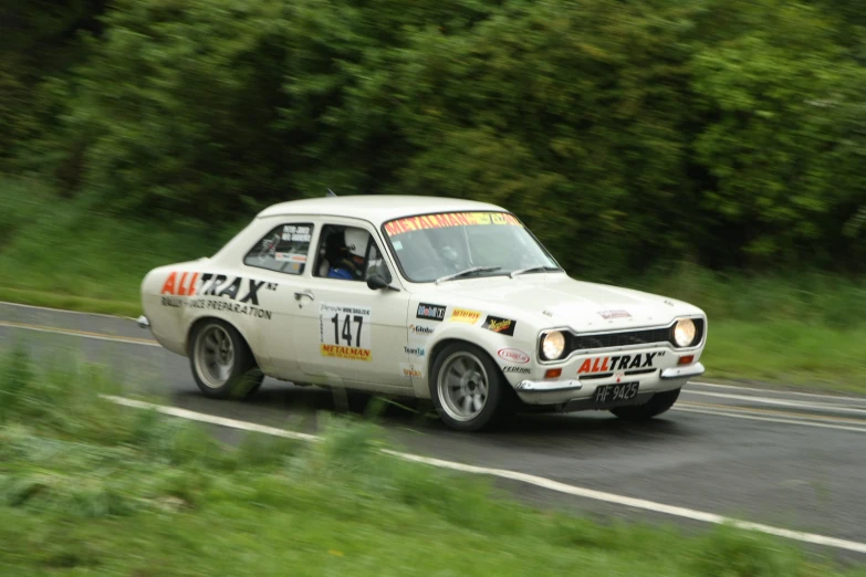 a car drives on the road with grass around