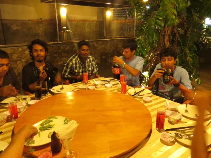 a group of people sitting at a wooden table