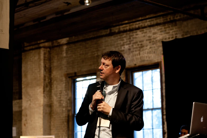 a man in a suit speaking into a microphone