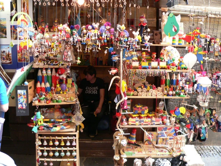 people sit outside of a building selling toys