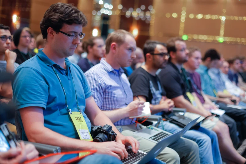 many men are sitting with laptops during a conference