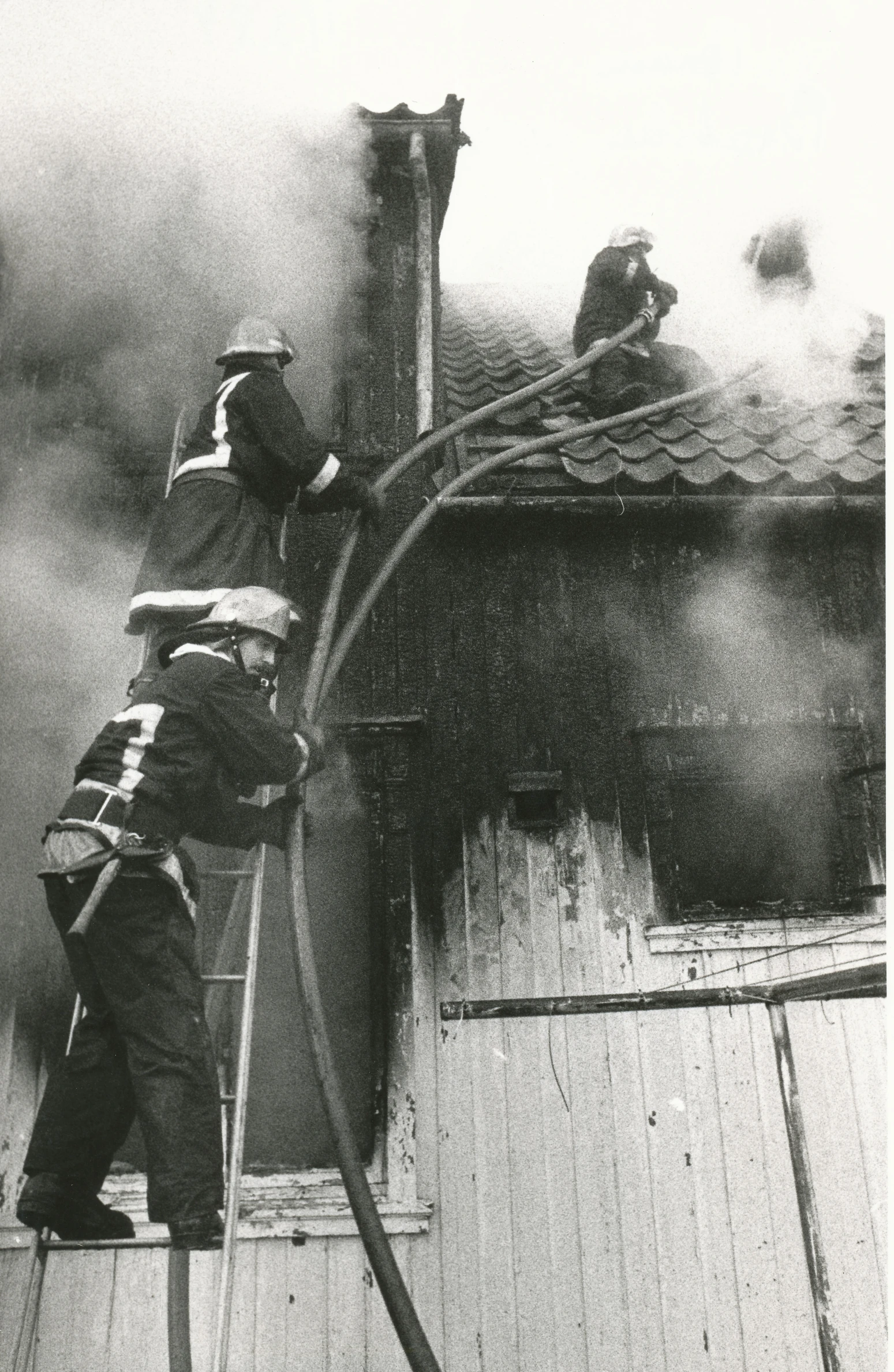 a man on a ladder in front of a fire