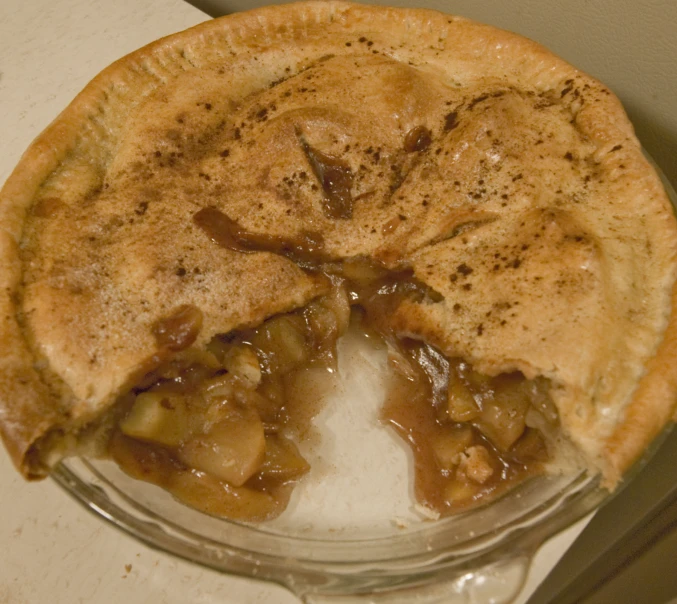 a apple pie cut in half and being eaten