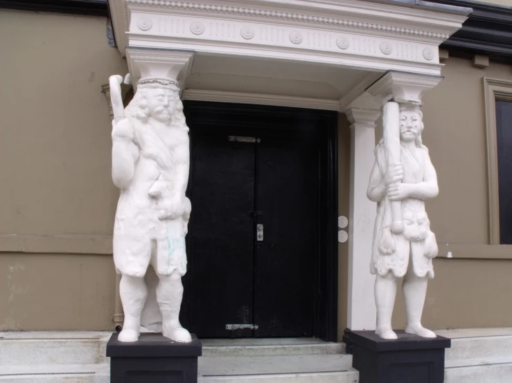 a couple of statues sitting on top of a pillar