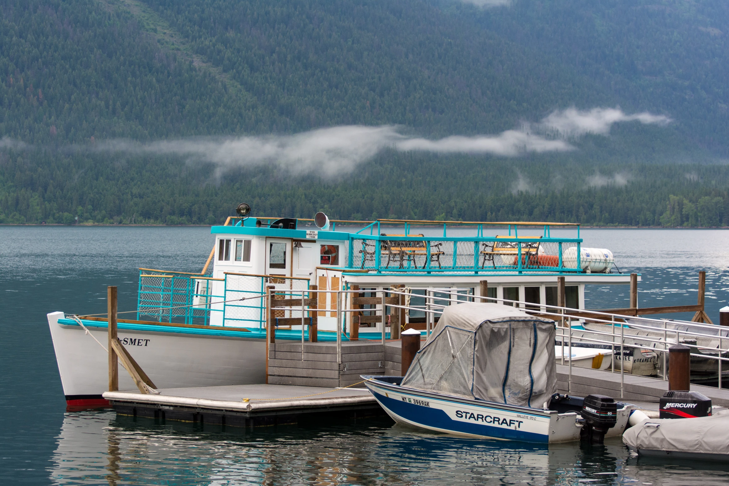 two boats parked in the water by the shore