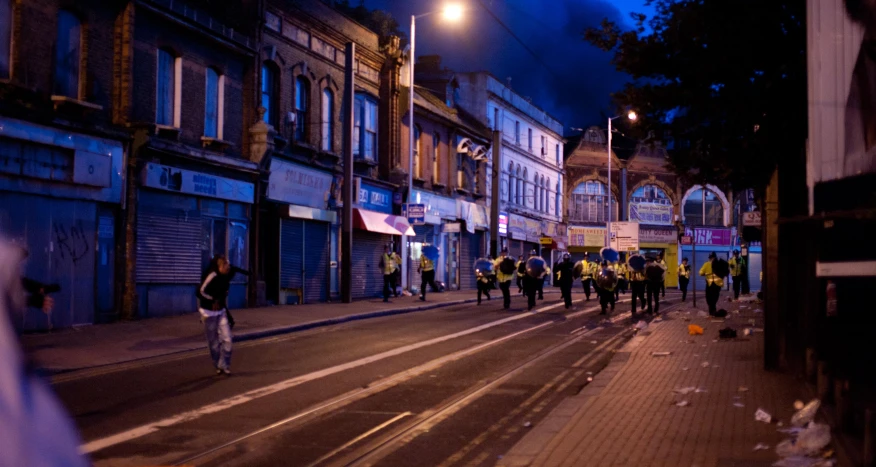 group of people walking down the street at night