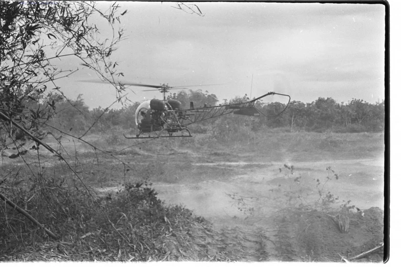 a helicopter sitting in a field near a river