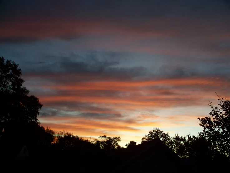 a beautiful sunset in the sky over houses