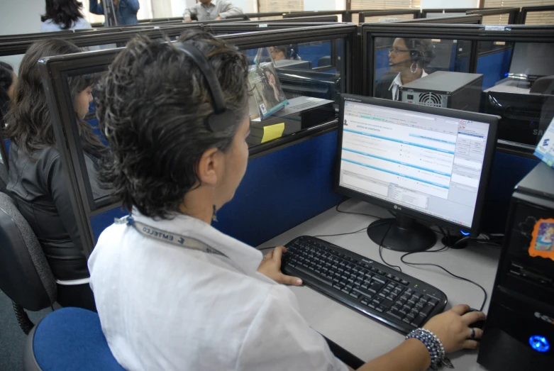 a woman is sitting at her desktop computer