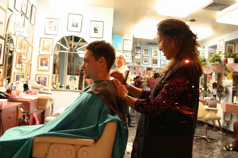 a woman getting her hair styled by a man