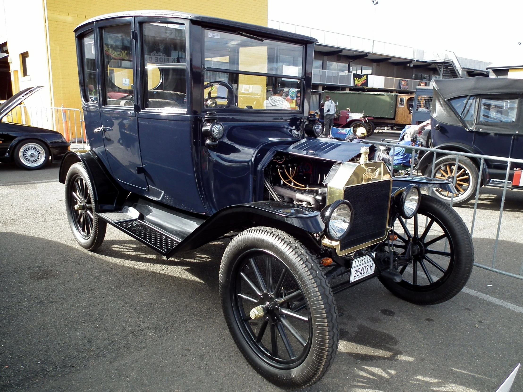 old model t car with man standing beside it