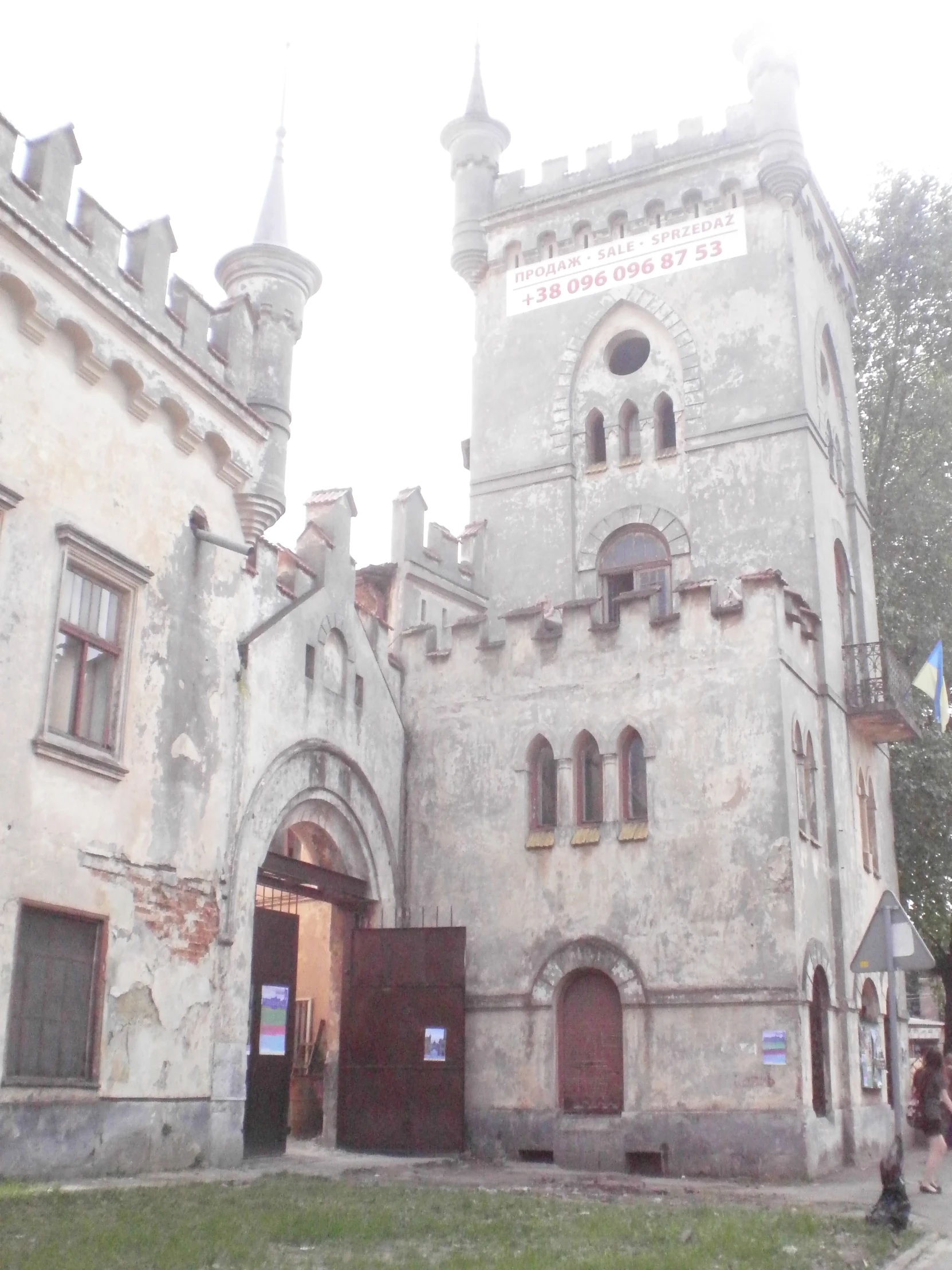 the castle door is open, with a woman walking in the doorway