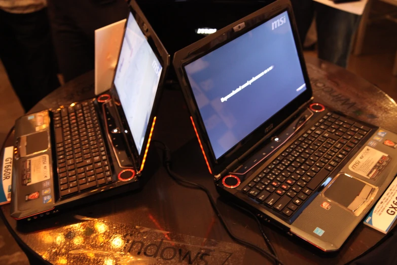 two laptops sitting on a table with their screens open