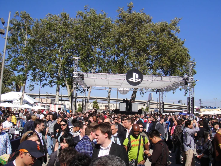 a crowd gathered together in front of a large stage