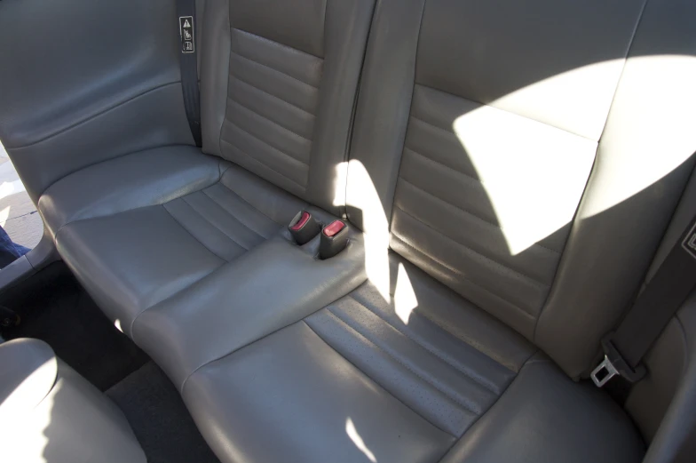 a grey car with four seat covers, two seats facing the opposite direction