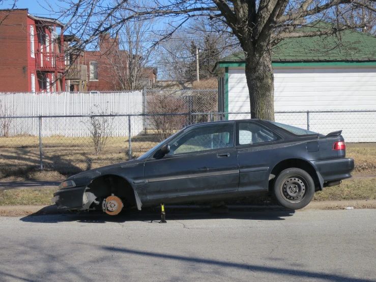 a car with it's tires propped up against a fence