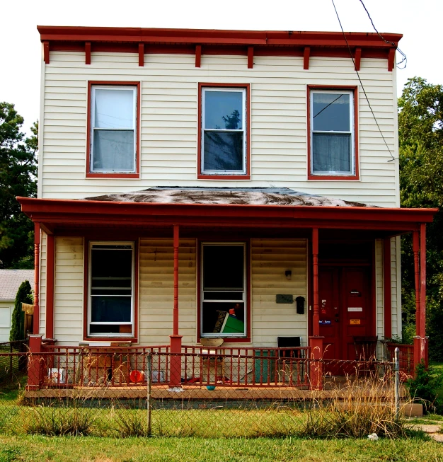 an old house sits empty in a vacant lot