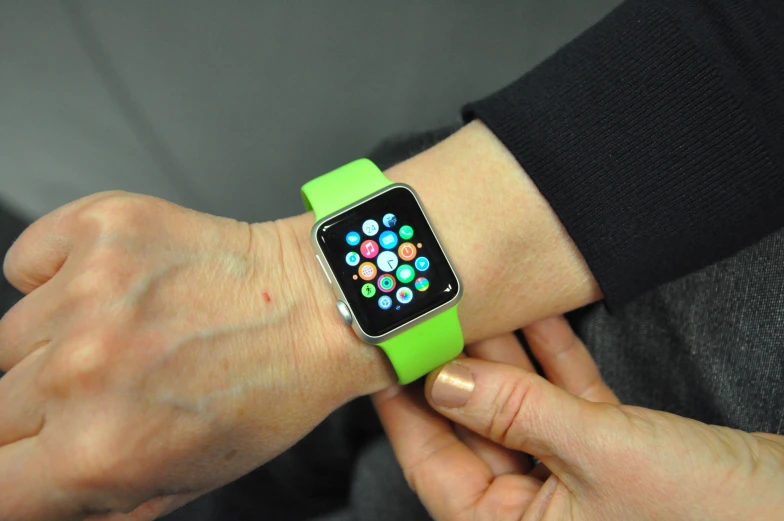 the apple watch with four app icons is on someone's wrist