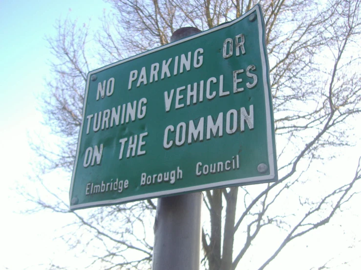 there is a sign that says no parking or turning vehicles on the common