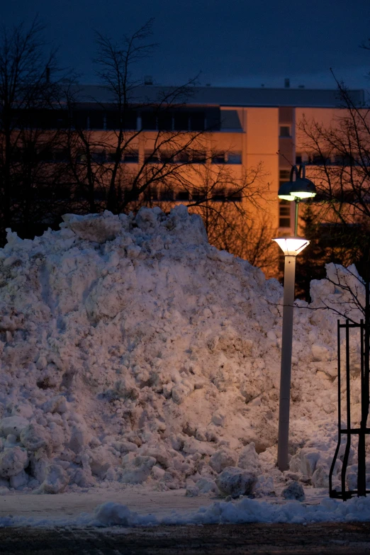 a snow covered road with trees and street lights