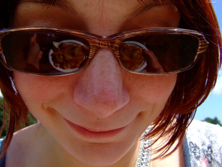 a woman wearing sunglasses with some food in them