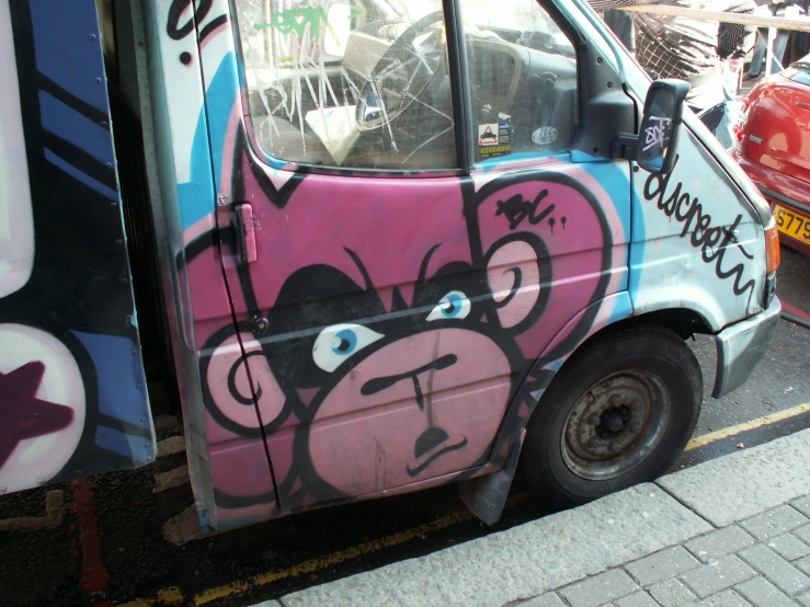 a graffiti covered van parked in front of a street sign